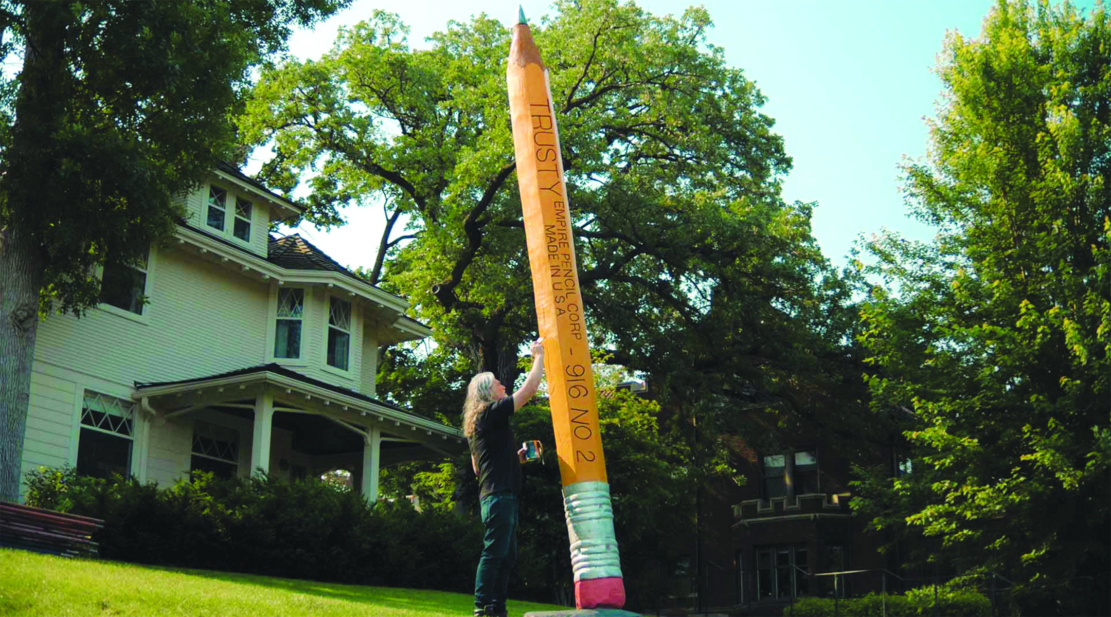 A familiar Lake of the Isles landmark, the 20-foot, chainsaw-carved No. 2 pencil stands tall on a neighborhood lawn, transformed from a fallen tree into a symbol of renewal and community ritual. The sculpture is featured in “A Short Documentary About A Giant Pencil,” part of Shorts 9: Eclectic Interests at the Minneapolis St. Paul International Film Festival. (Image: MSPfilm.org)